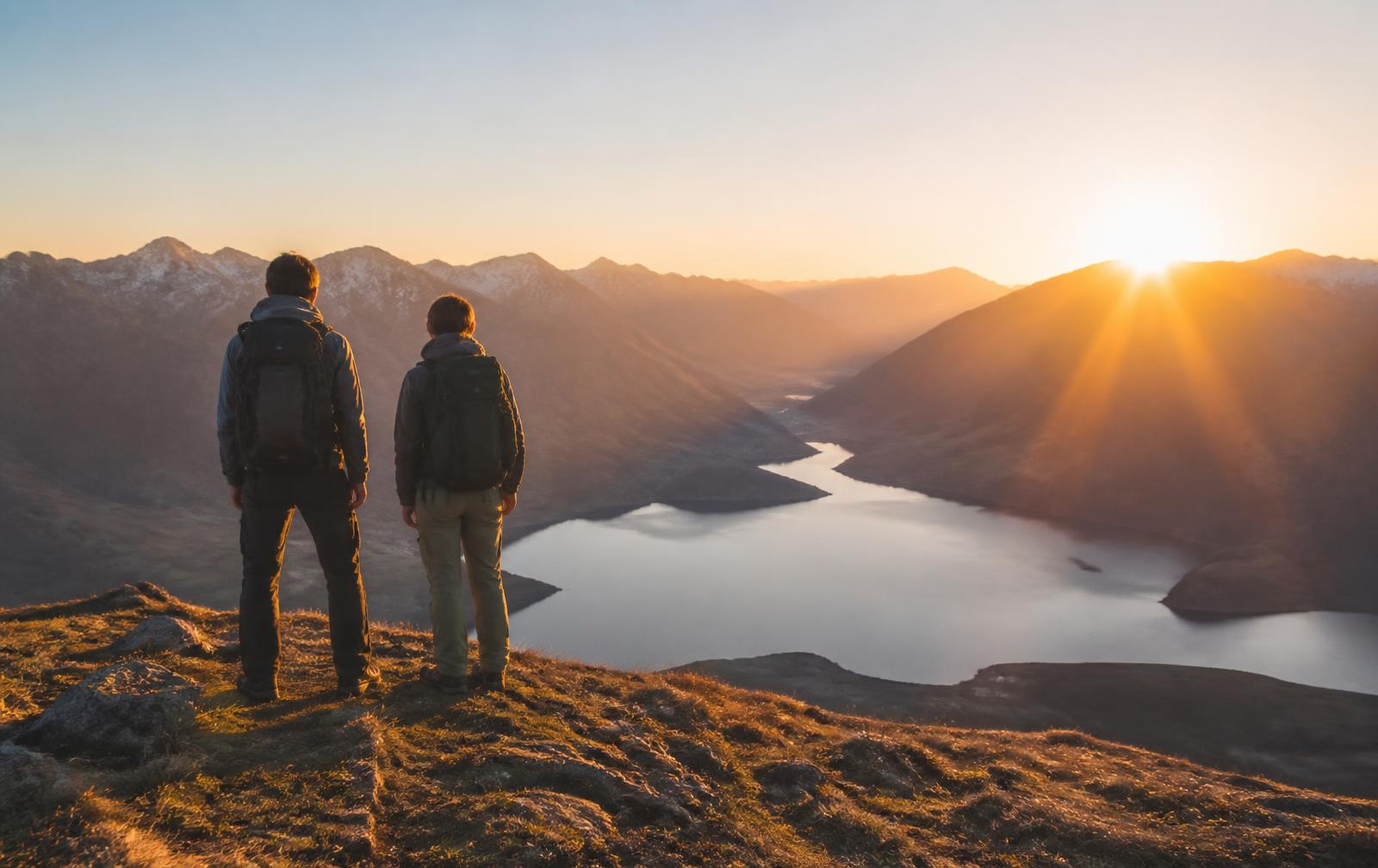 Zwei Bergwanderer auf einem Grat bei Sonnenaufgang